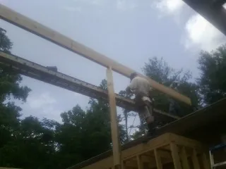 Carpenter setting a ridge beam over a new addition frame — Ice Dam Removal by Roofing Brothers in Hackleburg