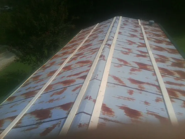 Rusted metal roof panels with new wood purlins before replacement — Storm Damage Roof Repair in Hackleburg by Roofing Brothers
