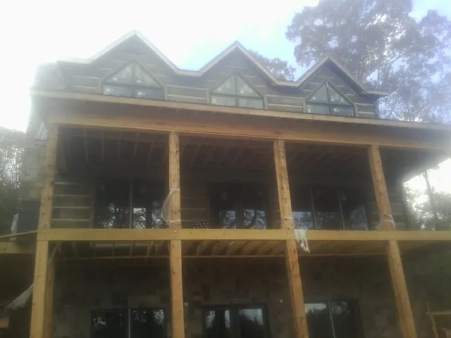 Dormers and porch framing on a large log home under construction — Roof Coating work by our crew in Hackleburg