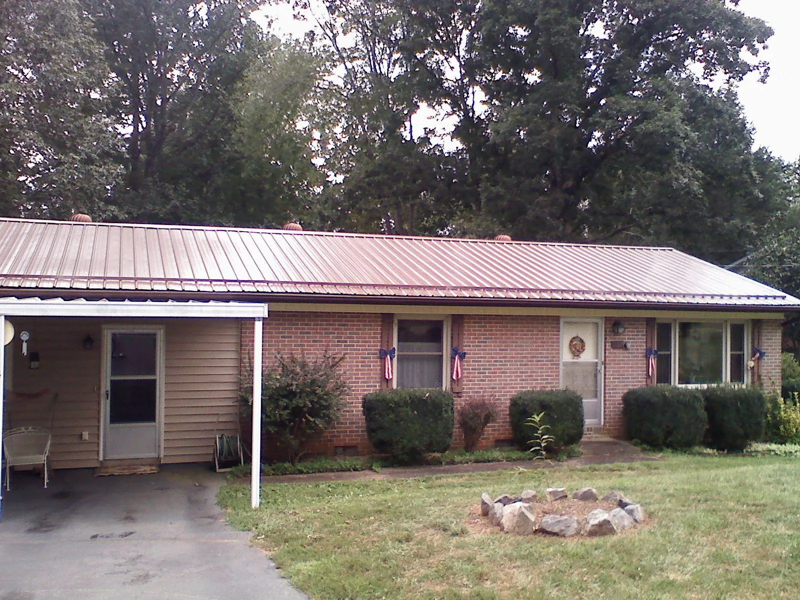 Bronze metal roof and carport on a brick ranch home — Roof Repair work by our crew in Hackleburg