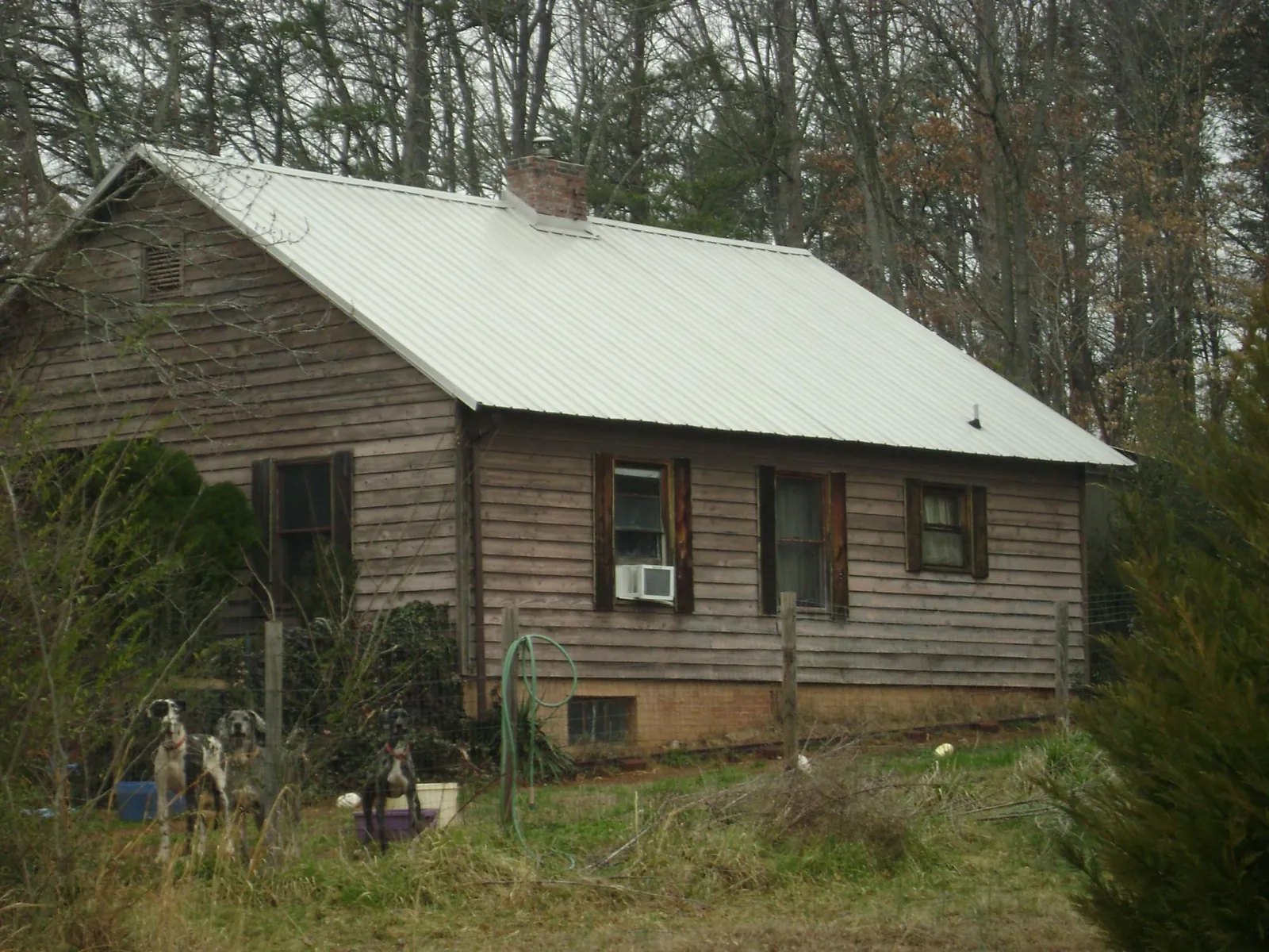White metal roof on an old wood sided farmhouse, from a Metal Roof Installation job in Hackleburg